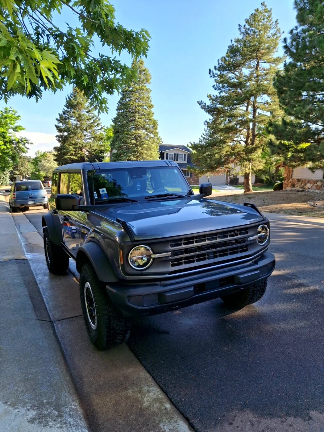 Dark Ford Bronco parked on a neighborhood street