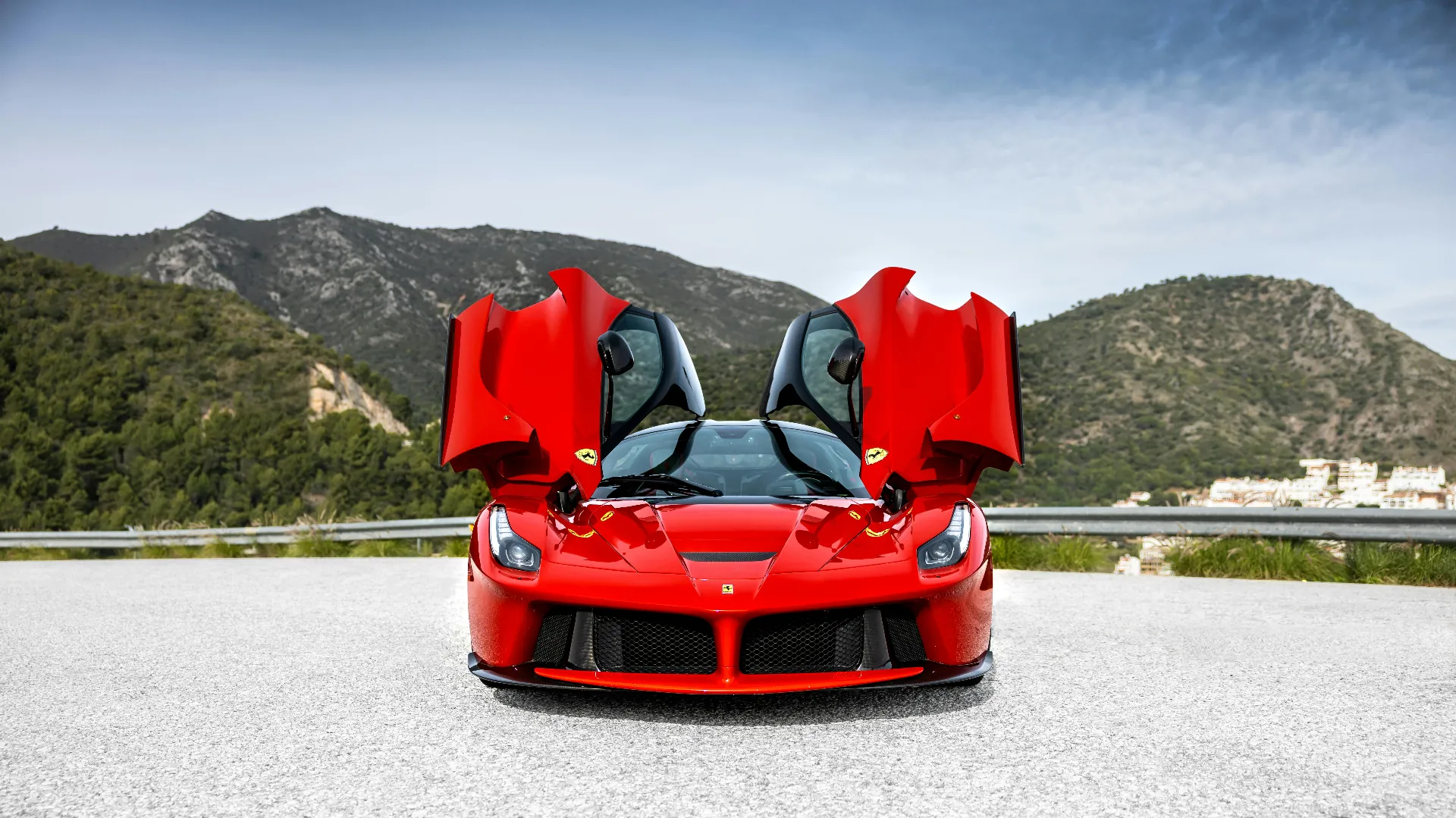 Red Ferrari LaFerrari with doors up in the mountains