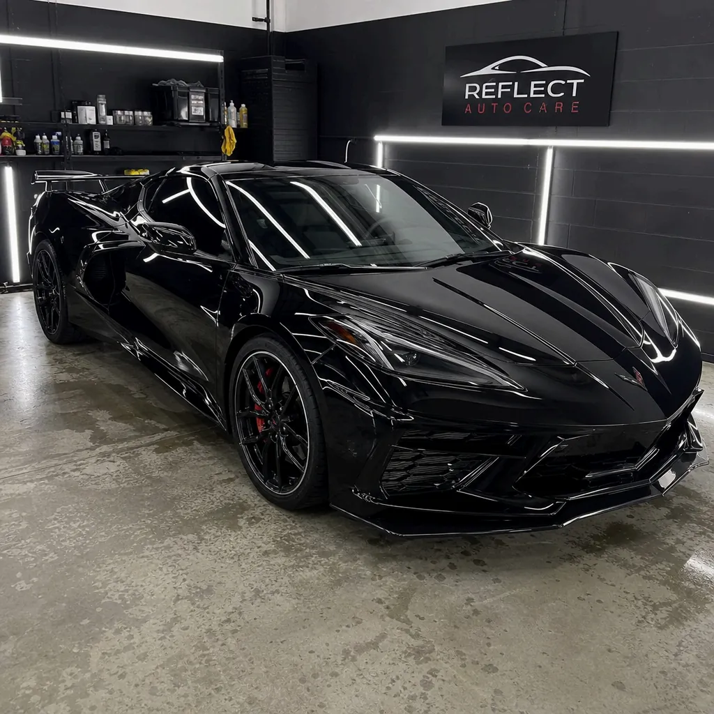 A black Chevrolet Corvette in a professional detailing shop